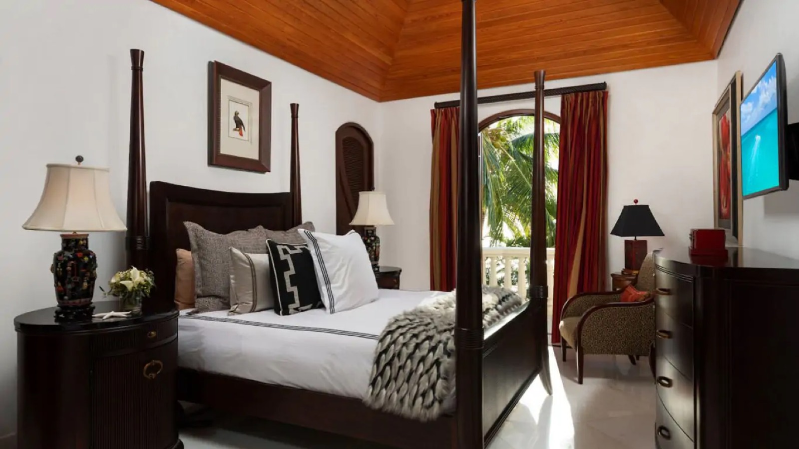 Four-poster bedroom under a timber ceiling