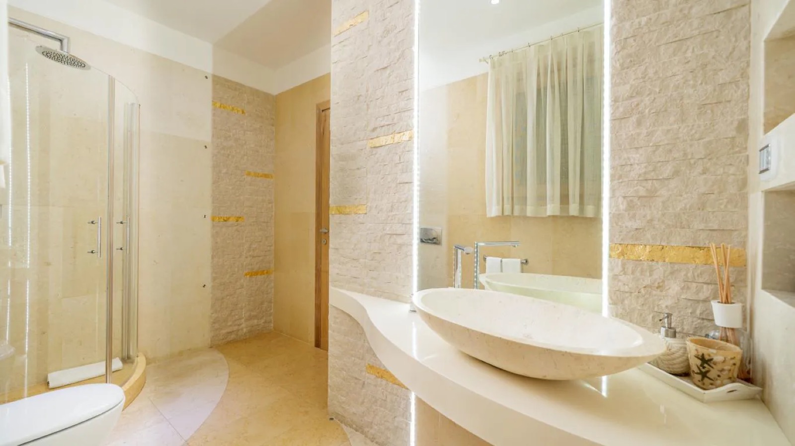Stone bathroom with oval basin and gold inlay