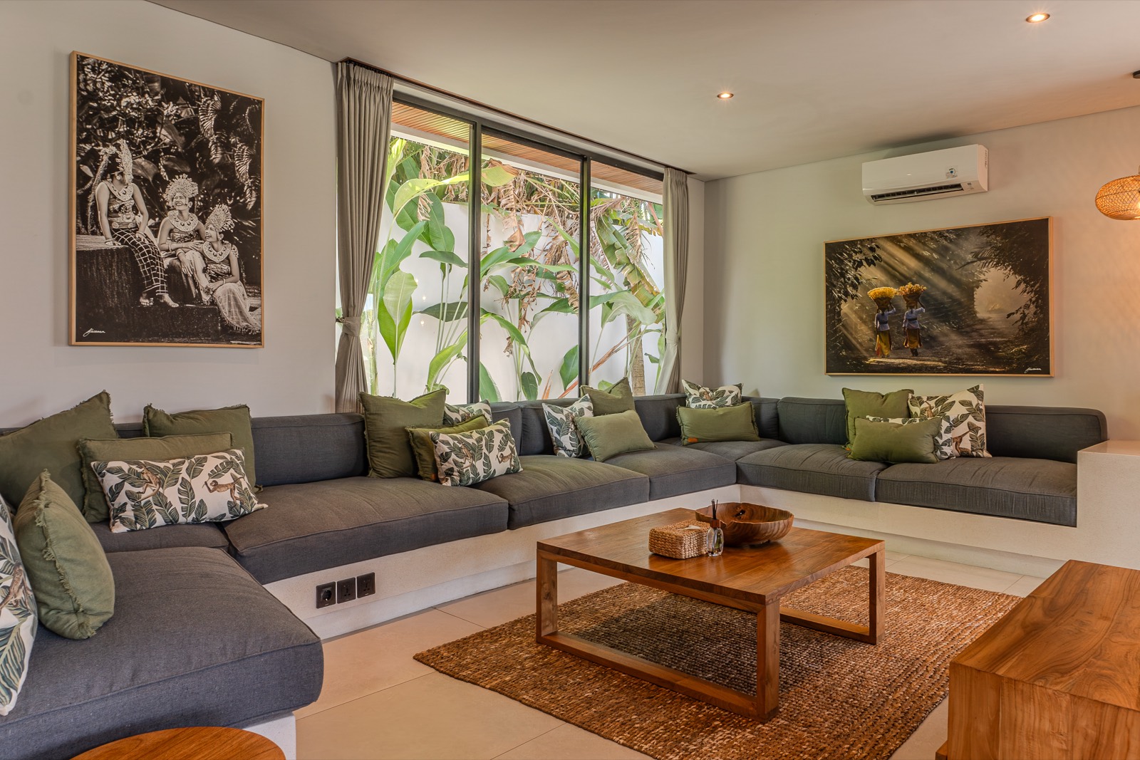 Corner sofa below framed Balinese photographs