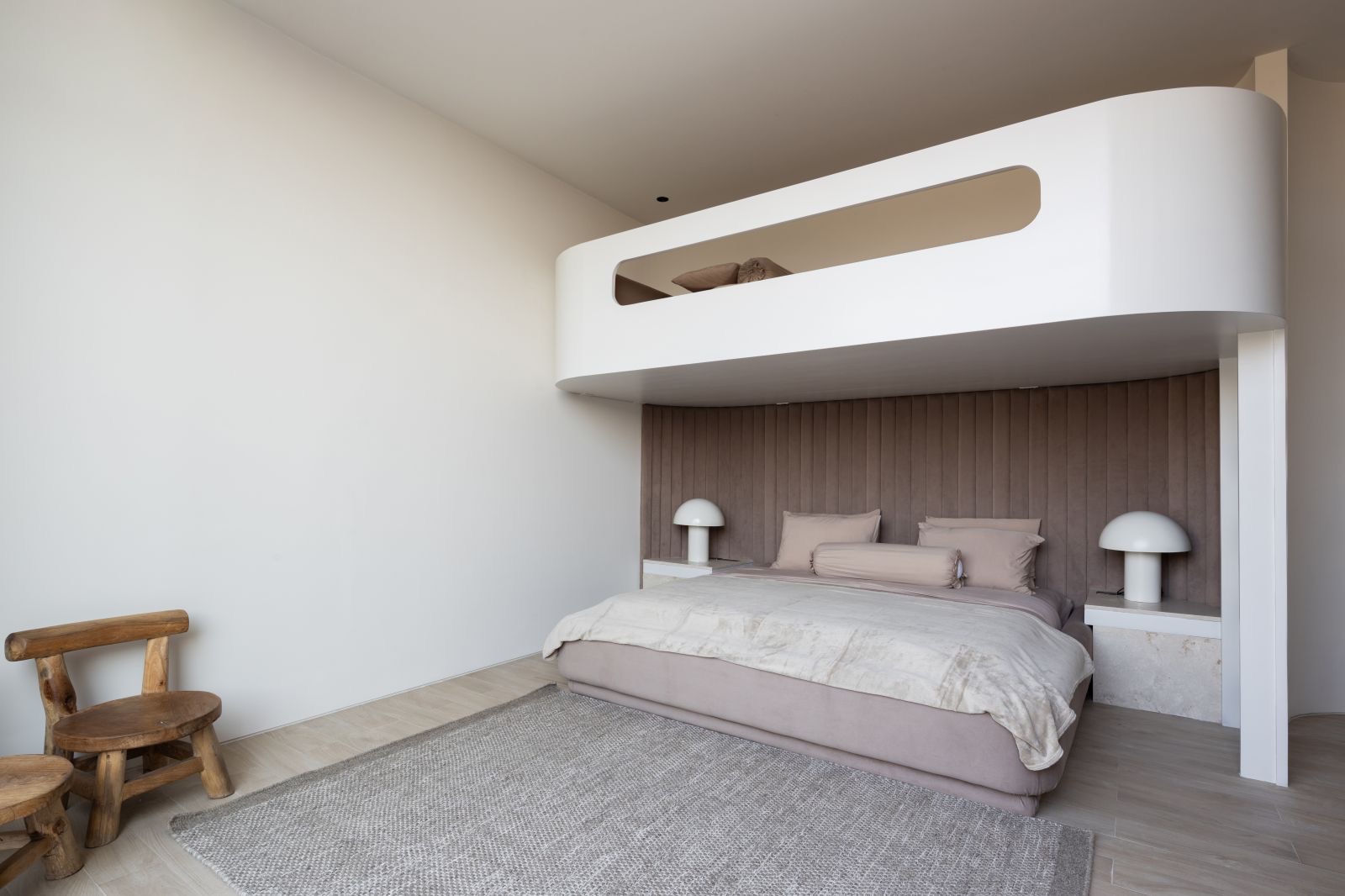 Bedroom beneath a curved mezzanine loft