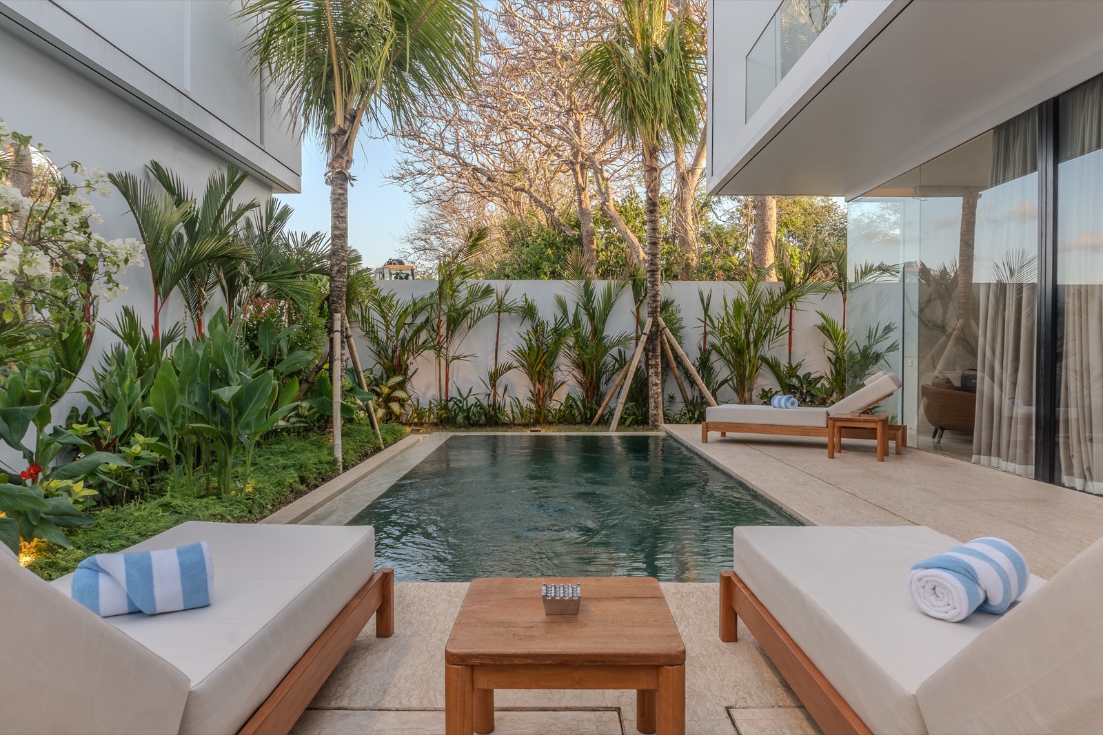 Teak daybeds facing the pool