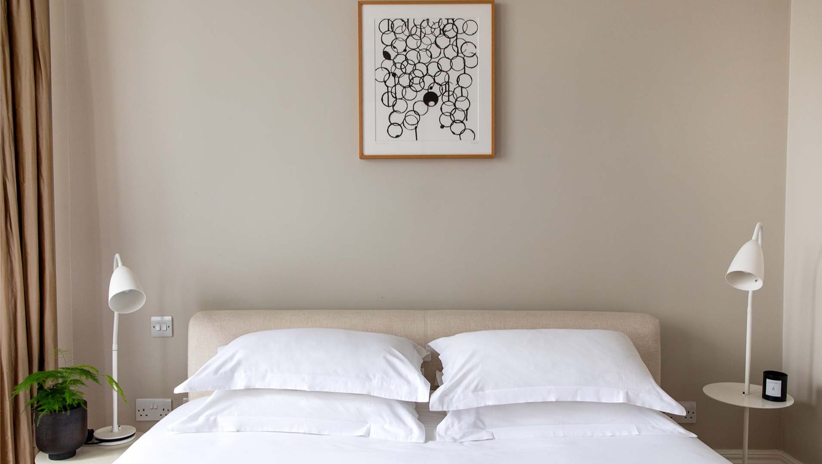 Super-king bed beneath a framed print