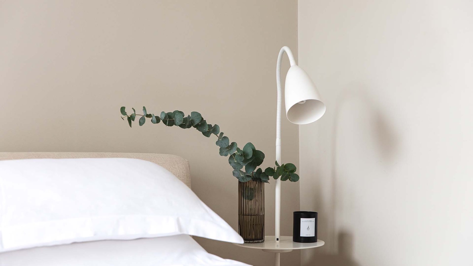 Bedside lamp and eucalyptus beside the bed
