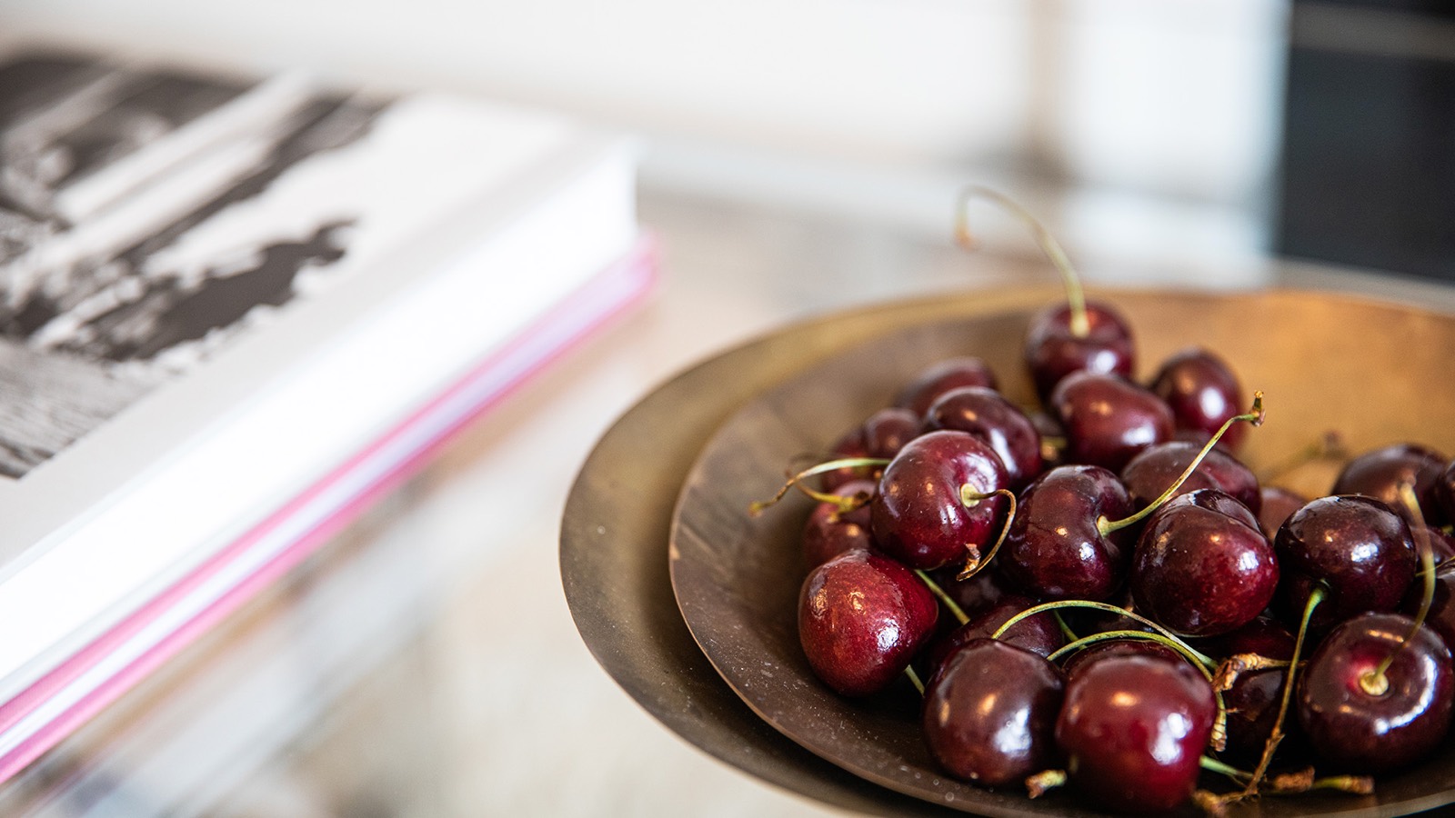 Cherries and books on the glass table