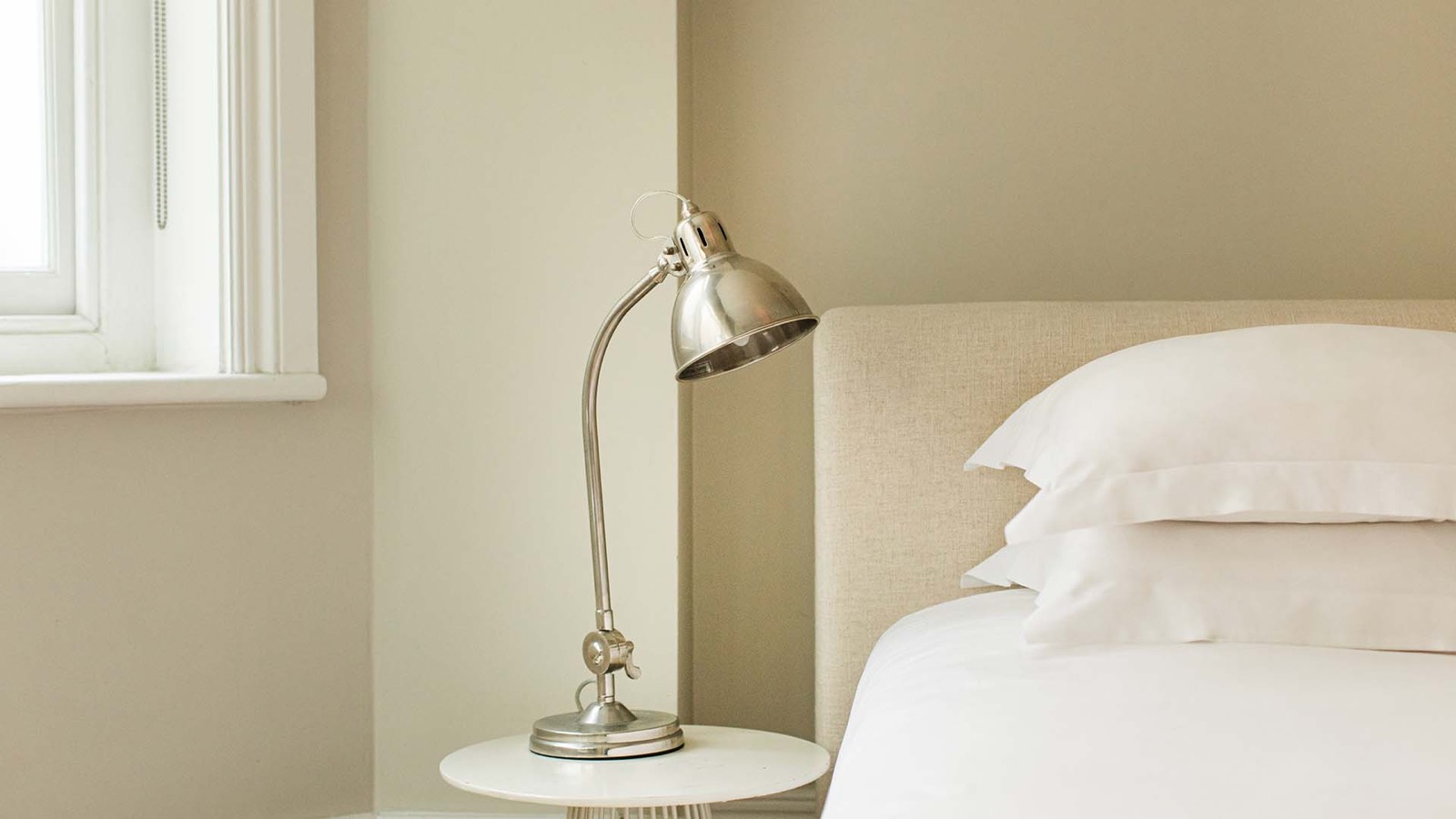 Nickel reading lamp beside the bed
