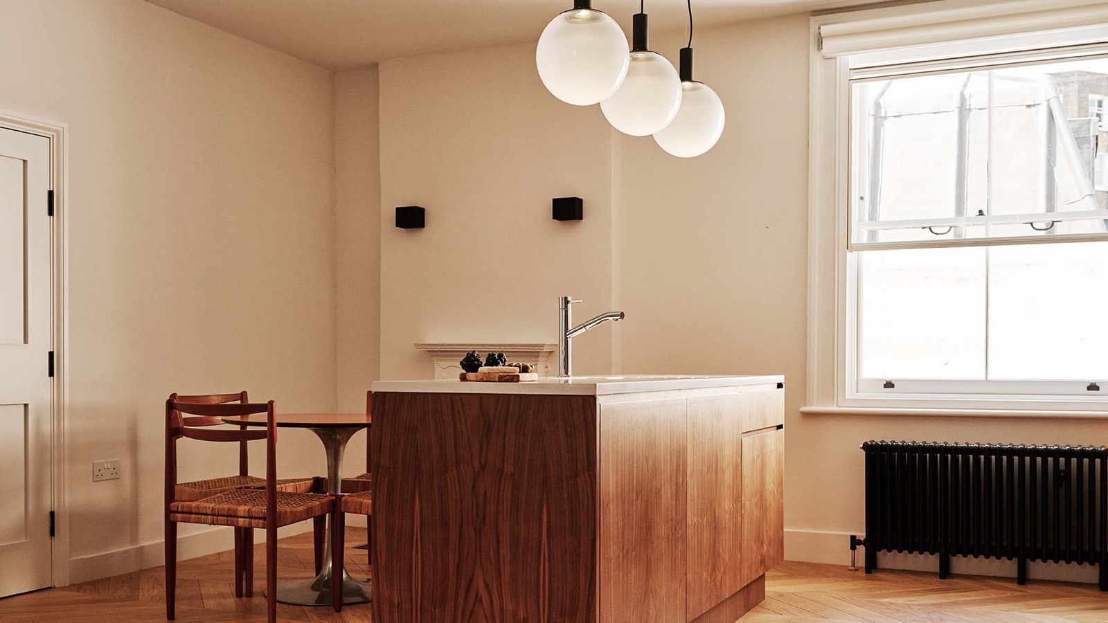 Kitchen island and dining table beneath globe pendants