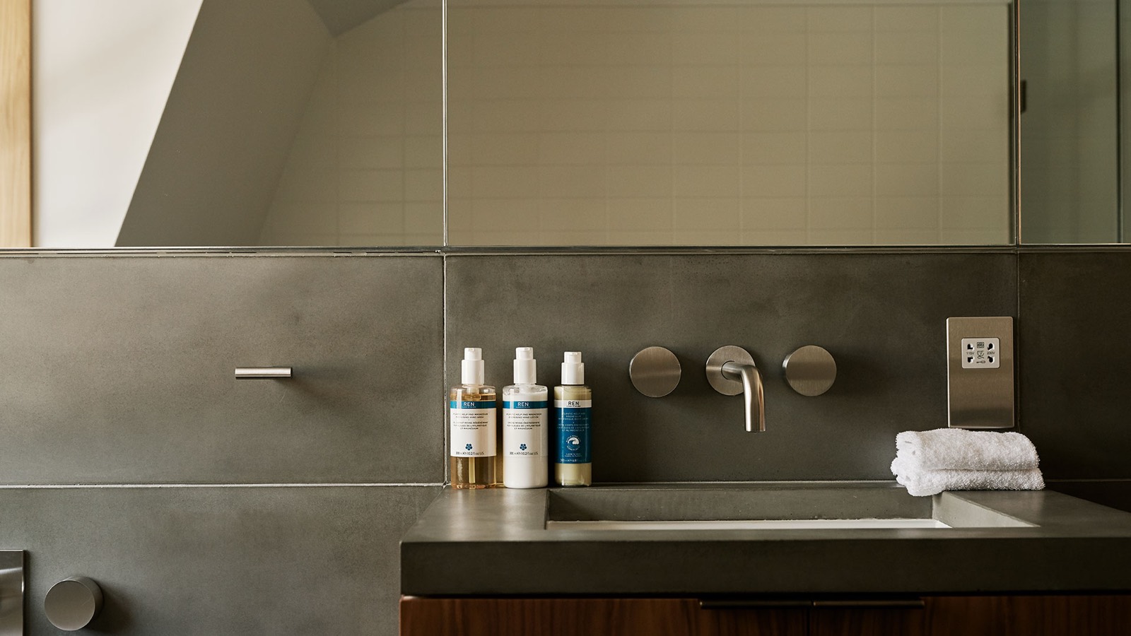 Stone washbasin below the mirrored cabinet