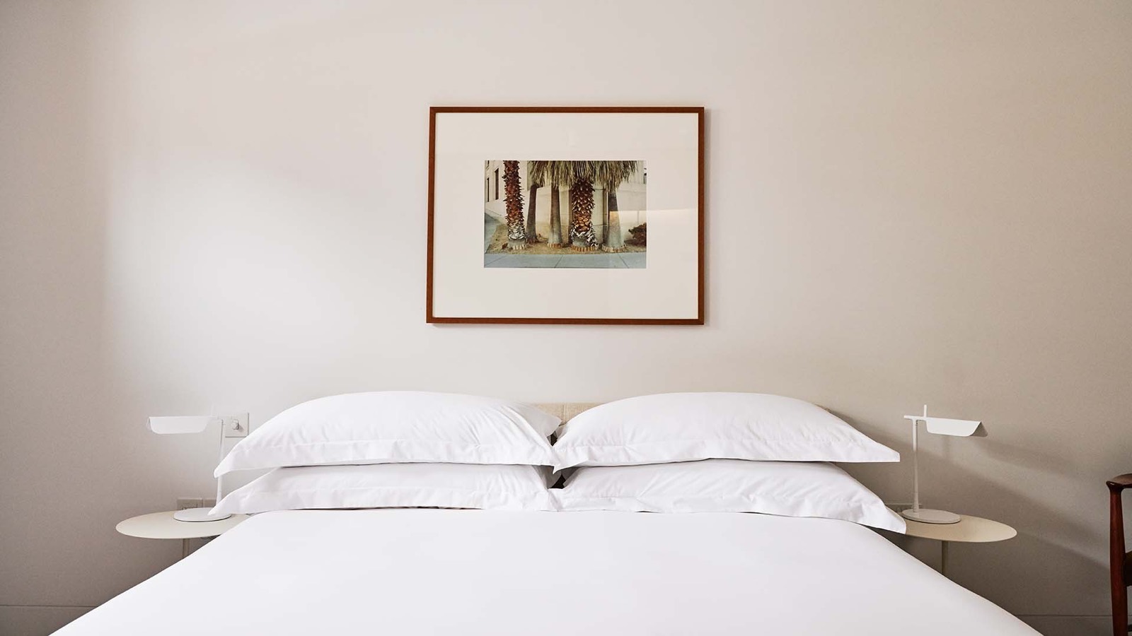 Bedroom beneath a framed palm photograph