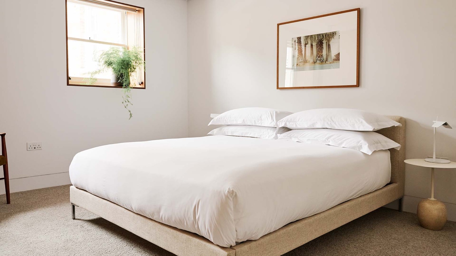 Bedroom with linen bed and window fern