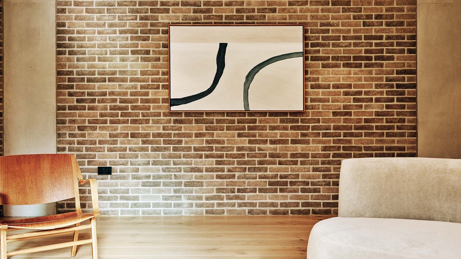 Exposed brick wall hung with a single artwork